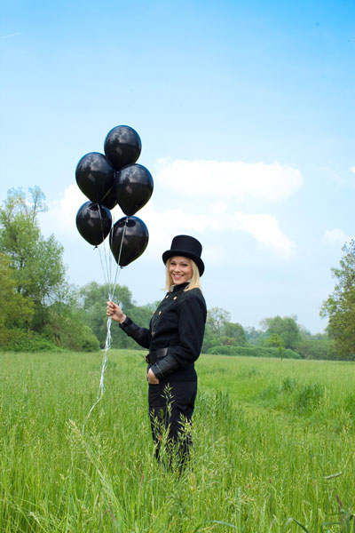 Schronsteinfegerin mit schwarzen Luftballons